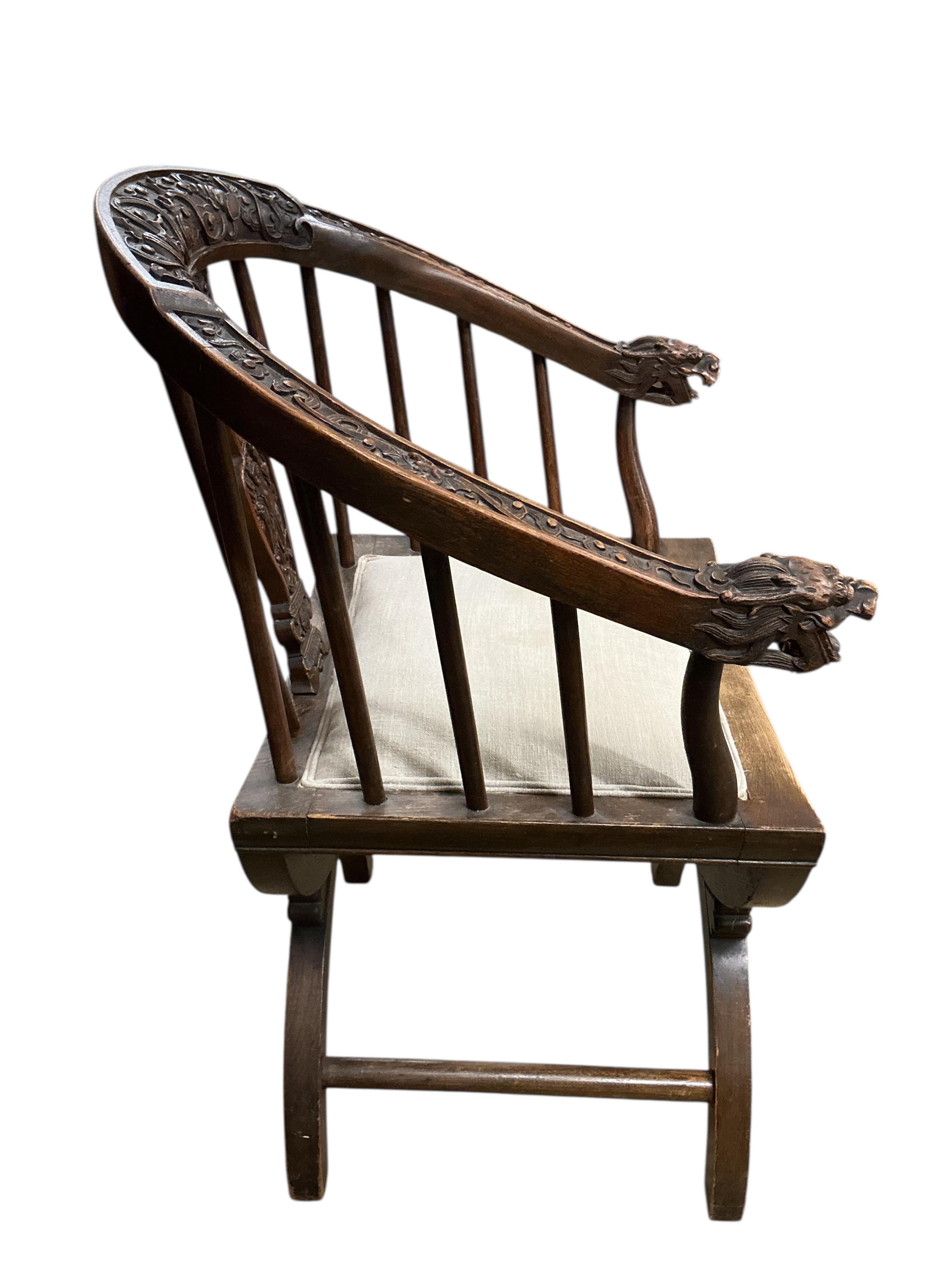 An Italian carved walnut 'X' frame elbow chair, width 58cm, depth 43cm, height 88cm